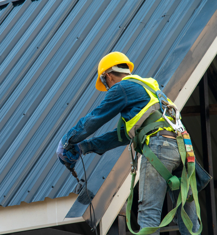man installs metal roofing